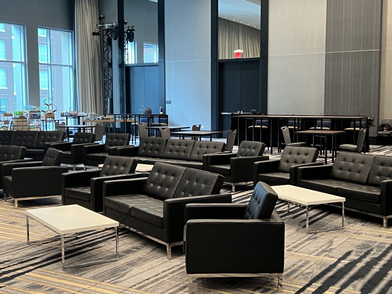 Conference furniture rental: rows of black leather lounge seating in a large conference lounge