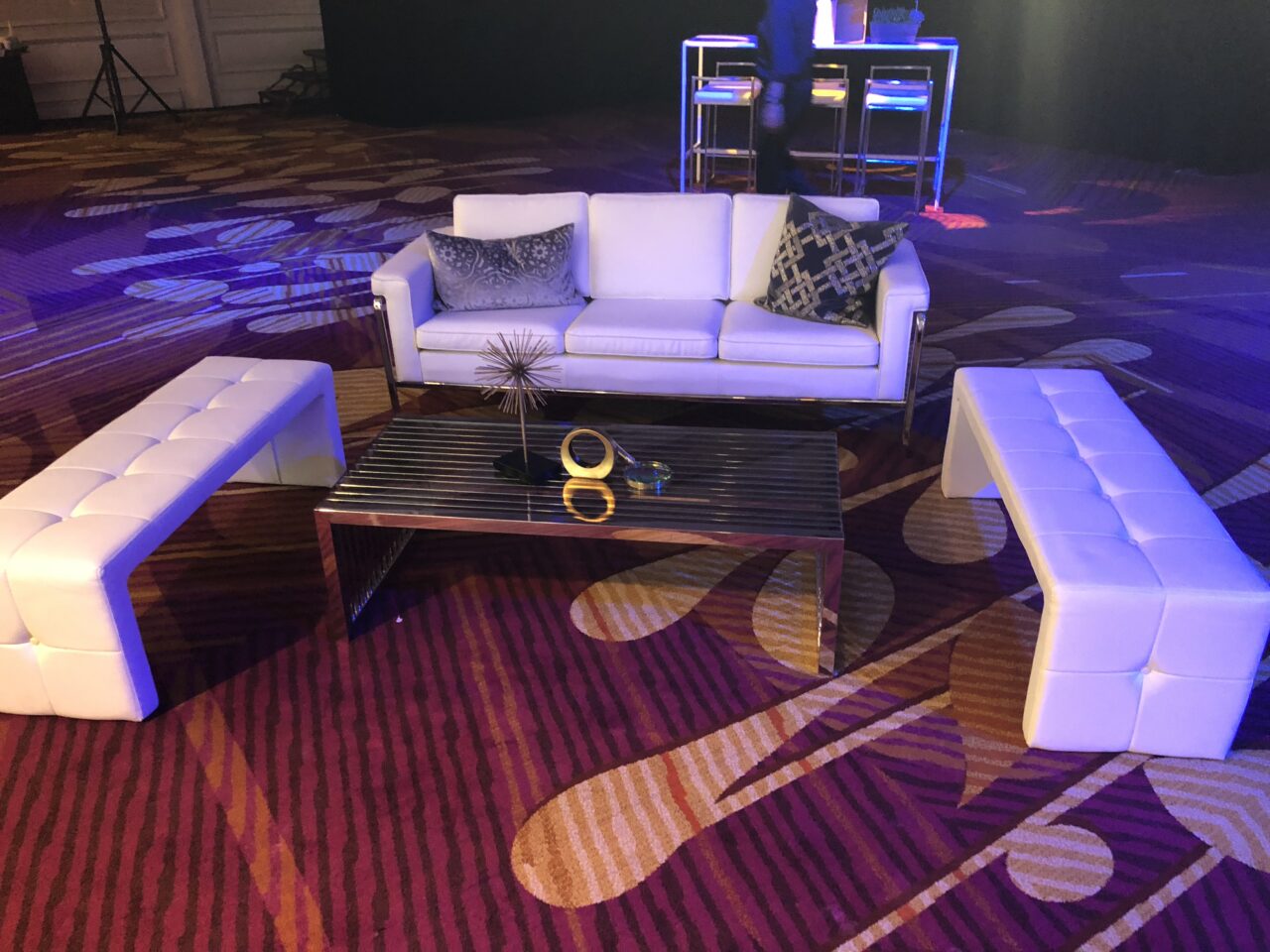 Branded event furniture: white lounge sofa and bench seating set up for a brand event