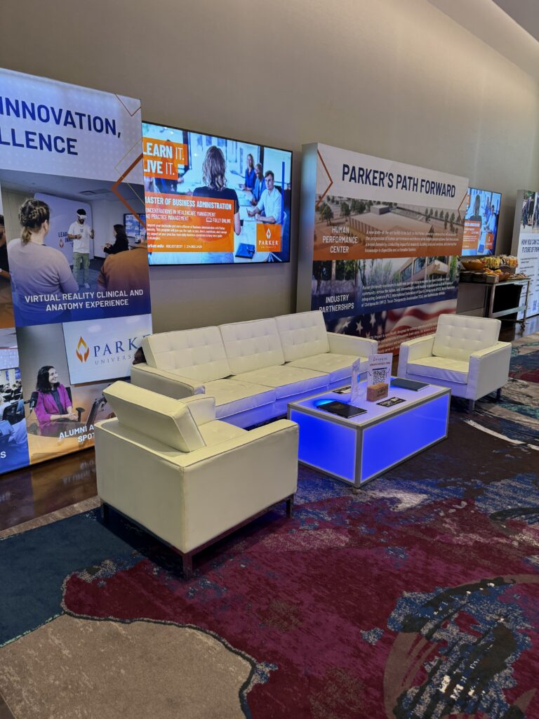Sponsor Lounge Furniture: How to Spec a Branded Lounge That Works 3 Branded lounge with white sofas and a blue illuminated cube table matching the sponsor color